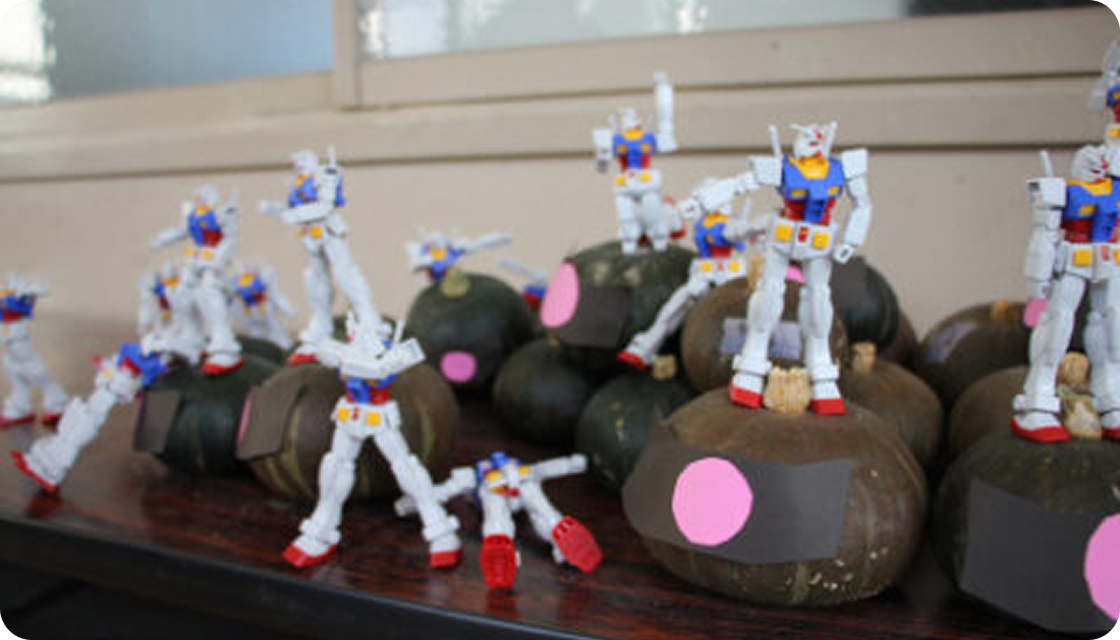 An image of Gunpla models being assembled by children through Gunpla Academia.